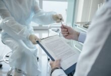 Profissional de saúde analisando documentos com paciente em consultório, representando comparação de planos
