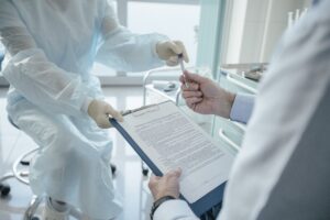 Profissional de saúde analisando documentos com paciente em consultório, representando comparação de planos