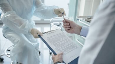 Profissional de saúde analisando documentos com paciente em consultório, representando comparação de planos