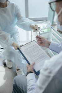 Paciente recebendo documento de profissional de saúde em consultório médico, representando plano de saúde